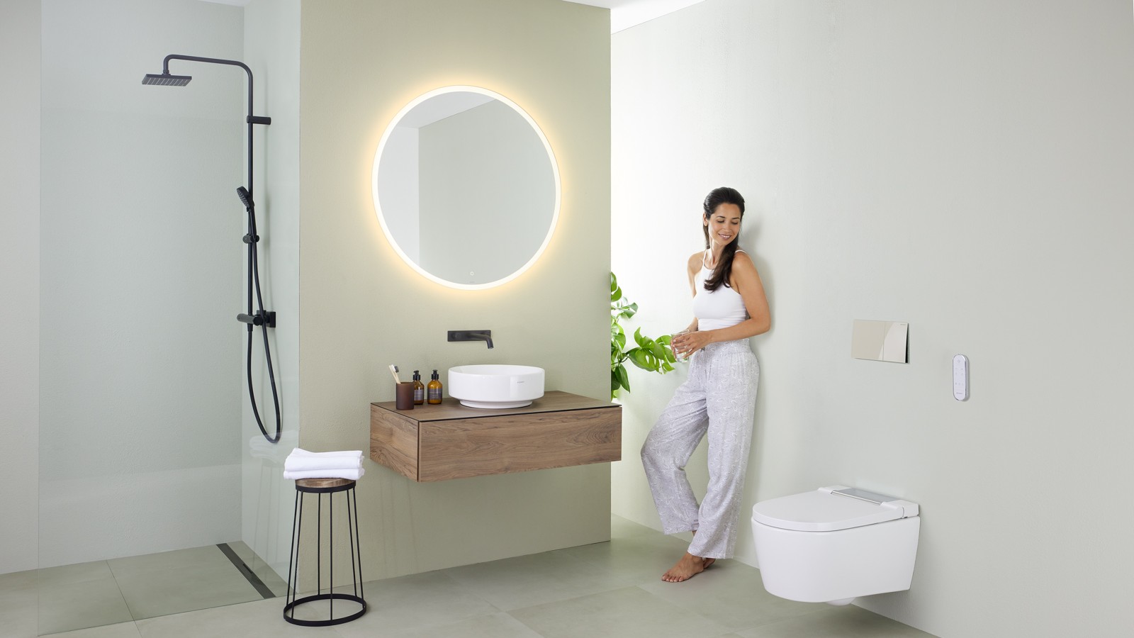 Woman in front of bathroom mirror (© Geberit) Woman in front of bathroom mirror (© Geberit)