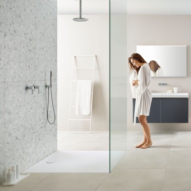 Woman in bathroom with walk-in shower and Geberit Olona shower tray Woman in bathroom with walk-in shower and Geberit Olona shower tray