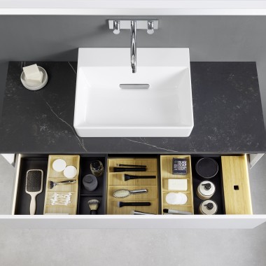 View from above into an open Geberit ONE washbasin drawer with organiser boxes View from above into an open Geberit ONE washbasin drawer with organiser boxes