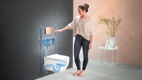 Woman presses actuator plate and flushes the Acanto WC Woman presses actuator plate and flushes the Acanto WC
