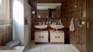 Bathroom with brown tiles and two washbasins Bathroom with brown tiles and two washbasins