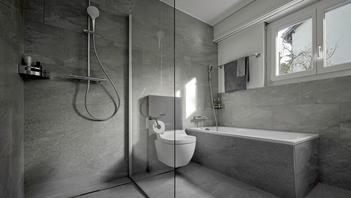 A shower toilet between a floor-standing shower and a bathtub A shower toilet between a floor-standing shower and a bathtub