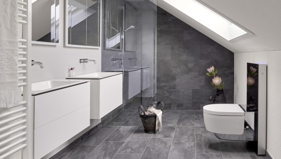Bathroom with sloping roof and products from the Geberit ONE bathroom series and Geberit AquaClean with Monolith Bathroom with sloping roof and products from the Geberit ONE bathroom series and Geberit AquaClean with Monolith